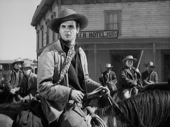 Movie still from “The Ox-Bow Incident” (1942), directed by William A. Wellman – A group of men on horses in front of a building; Medium shot, Low angle