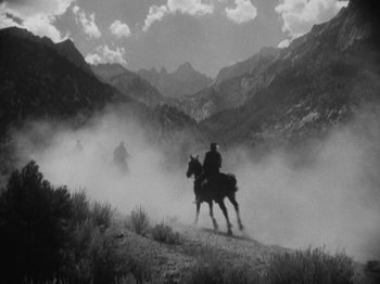 Movie still from “The Ox-Bow Incident” (1942), directed by William A. Wellman – A black and white photo of two people riding horses; Extreme Wide shot, Low angle
