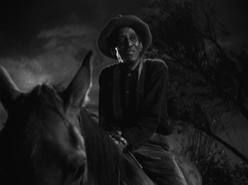 Movie still from “The Ox-Bow Incident” (1942), directed by William A. Wellman – A man sitting on top of a horse in the dark; Medium shot, Low angle