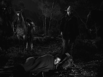 Movie still from “The Ox-Bow Incident” (1942), directed by William A. Wellman – A woman laying on the ground next to a horse; Wide shot, High angle
