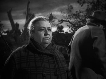 Movie still from “The Ox-Bow Incident” (1942), directed by William A. Wellman – An older woman standing in front of a tree; Close Up shot, Low angle
