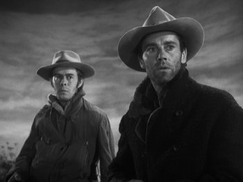 Movie still from “The Ox-Bow Incident” (1942), directed by William A. Wellman – Two men in hats and coats standing next to each other; Close Up shot, Low angle