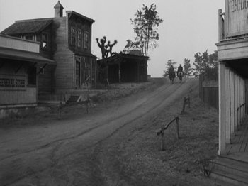 Movie still from “The Ox-Bow Incident” (1942), directed by William A. Wellman – A dirt road that has a house on the side of the road; Extreme Wide shot, High angle