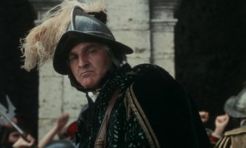Movie still from “The Pit and the Pendulum” (1991), directed by Stuart Gordon – A person wearing a helmet; Close Up shot, Low angle