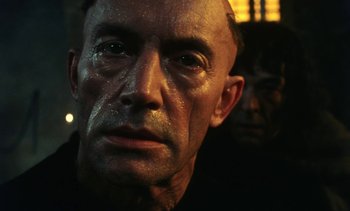 Movie still from “The Pit and the Pendulum” (1991), directed by Stuart Gordon – A man's face in front of another man; Close Up shot, Low angle