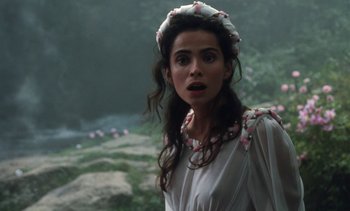 Movie still from “The Pit and the Pendulum” (1991), directed by Stuart Gordon – A woman in a white dress with pink flowers in her hair; Close Up shot, Over the shoulder angle