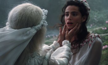 Movie still from “The Pit and the Pendulum” (1991), directed by Stuart Gordon – A woman in a white dress is touching a woman's face; Close Up shot, Over the shoulder angle