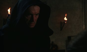Movie still from “The Pit and the Pendulum” (1991), directed by Stuart Gordon – A man in a black robe and a hooded cloak; Close Up shot, Over the shoulder angle
