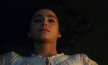 Movie still from “The Pit and the Pendulum” (1991), directed by Stuart Gordon – A young woman in a white dress looking up at the sky; Close Up shot, Overhead angle