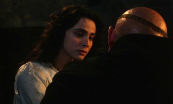 Movie still from “The Pit and the Pendulum” (1991), directed by Stuart Gordon – A man and a woman standing next to each other; Close Up shot, Over the shoulder angle