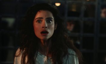 Movie still from “The Pit and the Pendulum” (1991), directed by Stuart Gordon – A woman with long dark hair stares into the camera; Close Up shot, Over the shoulder angle