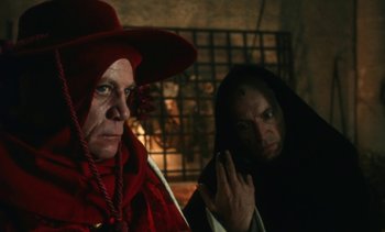 Movie still from “The Pit and the Pendulum” (1991), directed by Stuart Gordon – A man and a woman dressed up in costumes; Close Up shot, Over the shoulder angle