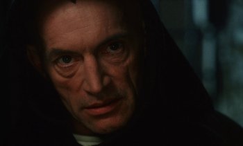Movie still from “The Pit and the Pendulum” (1991), directed by Stuart Gordon – A person wearing a black robe; Close Up shot, Low angle