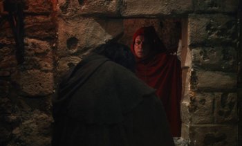 Movie still from “The Pit and the Pendulum” (1991), directed by Stuart Gordon – A woman wearing a red robe and a black veil; Medium shot, Over the shoulder angle