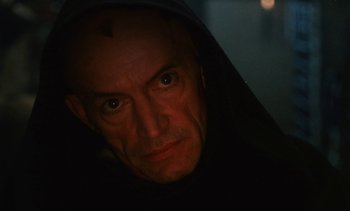 Movie still from “The Pit and the Pendulum” (1991), directed by Stuart Gordon – A person wearing a hood; Close Up shot, Low angle