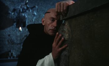 Movie still from “The Pit and the Pendulum” (1991), directed by Stuart Gordon – A man leaning against a wall with his hand on the wall; Close Up shot, High angle