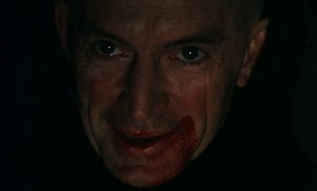 Movie still from “The Pit and the Pendulum” (1991), directed by Stuart Gordon – A person with blood all over his face; Extreme Close Up shot, High angle