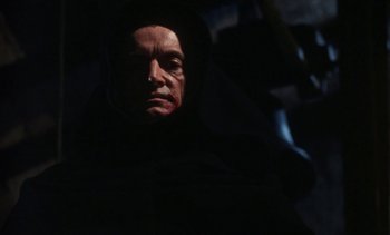 Movie still from “The Pit and the Pendulum” (1991), directed by Stuart Gordon – A person wearing a hooded robe; Close Up shot, Low angle