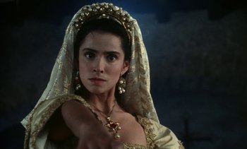 Movie still from “The Pit and the Pendulum” (1991), directed by Stuart Gordon – A woman wearing a gold dress and a veil; Close Up shot, Low angle