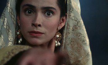 Movie still from “The Pit and the Pendulum” (1991), directed by Stuart Gordon – A person wearing a headdress; Close Up shot, Over the shoulder angle