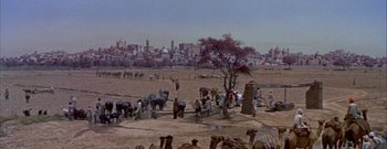 Movie still from “The Rains of Ranchipur” (1955), directed by Jean Negulesco – A group of people standing next to each other on top of a dirt field; Extreme Wide shot, High angle
