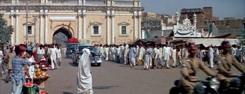 Movie still from “The Rains of Ranchipur” (1955), directed by Jean Negulesco – A group of people walking down a street; Wide shot, High angle