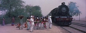 Movie still from “The Rains of Ranchipur” (1955), directed by Jean Negulesco – A group of people standing next to a train; Wide shot, High angle
