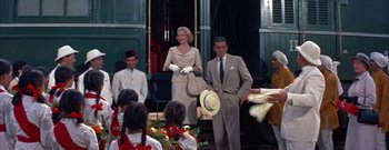 Movie still from “The Rains of Ranchipur” (1955), directed by Jean Negulesco – A man and a woman standing next to each other on a train platform; Medium shot, Low angle