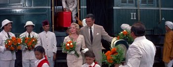 Movie still from “The Rains of Ranchipur” (1955), directed by Jean Negulesco – A man and a woman walking down the steps of a building; Medium shot, Over the shoulder angle