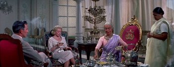 Movie still from “The Rains of Ranchipur” (1955), directed by Jean Negulesco – Two women sitting at a table with a tea set; Medium shot, Low angle