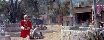 Movie still from “The Rains of Ranchipur” (1955), directed by Jean Negulesco – A group of people sitting on a dirt road; Extreme Wide shot, High angle