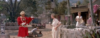 Movie still from “The Rains of Ranchipur” (1955), directed by Jean Negulesco – A woman standing in the middle of an outdoor area; Wide shot, Low angle