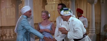 Movie still from “The Rains of Ranchipur” (1955), directed by Jean Negulesco – A group of people standing next to each other holding wine glasses; Medium shot, Over the shoulder angle