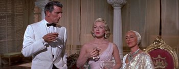 Movie still from “The Rains of Ranchipur” (1955), directed by Jean Negulesco – A man and a woman are standing in front of a window; Medium shot, Low angle