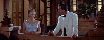 Movie still from “The Rains of Ranchipur” (1955), directed by Jean Negulesco – A man and a woman sitting at a counter; Medium shot, Over the shoulder angle