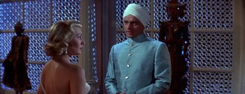 Movie still from “The Rains of Ranchipur” (1955), directed by Jean Negulesco – A man in a turban and a woman in a blue dress; Medium shot, Low angle