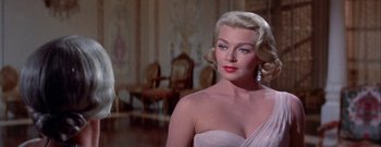 Movie still from “The Rains of Ranchipur” (1955), directed by Jean Negulesco – A woman with blonde hair wearing a strapless dress; Close Up shot, Low angle