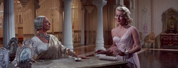 Movie still from “The Rains of Ranchipur” (1955), directed by Jean Negulesco – Two women are sitting at a table in a room; Medium shot, Low angle