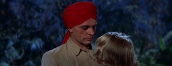Movie still from “The Rains of Ranchipur” (1955), directed by Jean Negulesco – A man wearing a red turban with a little blond girl; Close Up shot, Low angle