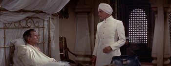 Movie still from “The Rains of Ranchipur” (1955), directed by Jean Negulesco – A man wearing a white turban and a white suit; Medium shot, High angle