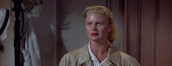 Movie still from “The Rains of Ranchipur” (1955), directed by Jean Negulesco – A woman with blonde hair wearing a white shirt and jacket; Close Up shot, Low angle