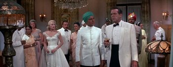 Movie still from “The Rains of Ranchipur” (1955), directed by Jean Negulesco – A group of people standing in a room; Medium shot, Low angle