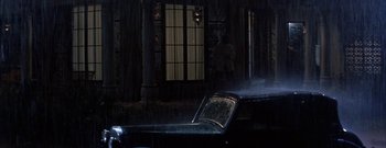 Movie still from “The Rains of Ranchipur” (1955), directed by Jean Negulesco – A car parked in front of a building at night; Wide shot, Low angle