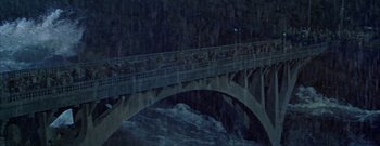 Movie still from “The Rains of Ranchipur” (1955), directed by Jean Negulesco – A group of people on a bridge in the rain; Extreme Wide shot, High angle