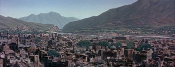 Movie still from “The Rains of Ranchipur” (1955), directed by Jean Negulesco – An aerial view of a city with mountains in the background; Extreme Wide shot, High angle