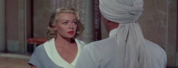 Movie still from “The Rains of Ranchipur” (1955), directed by Jean Negulesco – A woman in a white shirt and a man in a white turban; Close Up shot, Over the shoulder angle