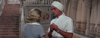 Movie still from “The Rains of Ranchipur” (1955), directed by Jean Negulesco – A man wearing a turban talking to a woman; Medium shot, Over the shoulder angle