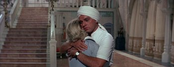 Movie still from “The Rains of Ranchipur” (1955), directed by Jean Negulesco – A man and a woman hugging in a room; Medium shot, Over the shoulder angle