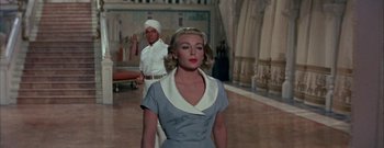 Movie still from “The Rains of Ranchipur” (1955), directed by Jean Negulesco – A man and a woman standing next to each other in a room; Medium shot, Low angle