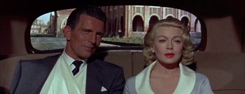 Movie still from “The Rains of Ranchipur” (1955), directed by Jean Negulesco – A man and a woman sitting next to each other in the back of a car; Close Up shot, Over the shoulder angle